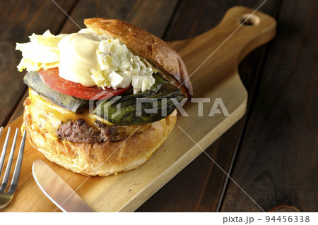 カッティングボードの上のアボカドチーズバーガーとナイフとフォーク カッティングボードの上のアボカドチーズバーガーとナイフとフォーク 94456338