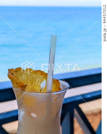 enjoying a dringk and a view of beach in oahu hawaii 94457012