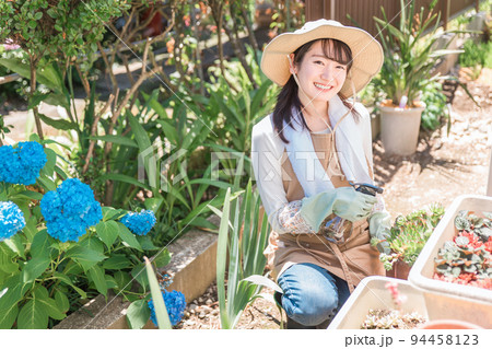 家の庭でガーデニングする女性（霧吹き） 94458123