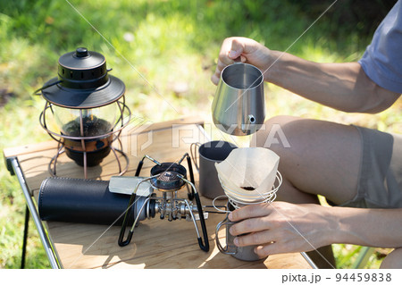 屋外でコーヒーをハンドドリップする様子 94459838