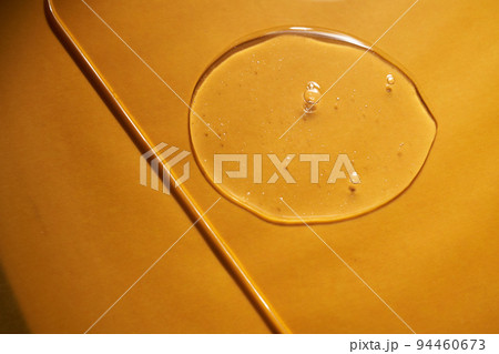 A drop of body gel or shampoo on a yellow saturated background. Texture. 94460673