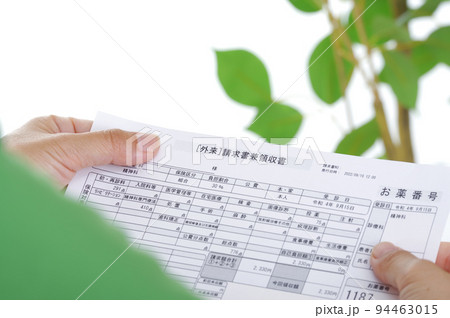 医療費の請求書を見つめる女性 94463015