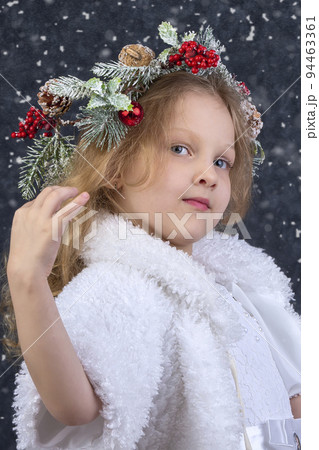 Beautiful little girl with a Christmas wreath on her head. Christmas child. Beautiful little girl with a Christmas wreath on her head. Christmas child. 94463361