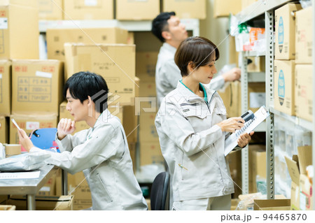 在庫管理をする作業着姿の女性 在庫管理をする作業着姿の女性 94465870