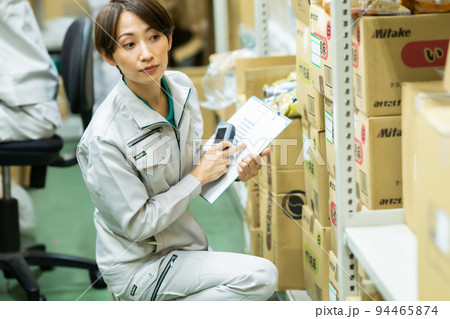 在庫管理をする作業着姿の女性 在庫管理をする作業着姿の女性 94465874