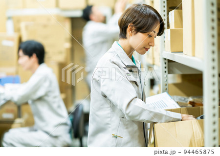 在庫管理をする作業着姿の女性 在庫管理をする作業着姿の女性 94465875