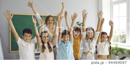 Funny group of elementary school classmates and their female teacher having fun in classroom. Funny group of elementary school classmates and their female teacher having fun in classroom. 94469097