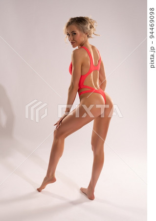 Slim woman wearing swimsuit in light studio 94469098