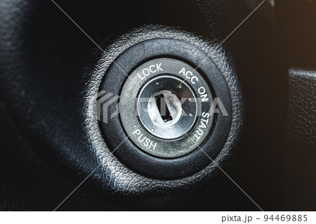 Car ignition lock under the steering wheel in a black interior 94469885