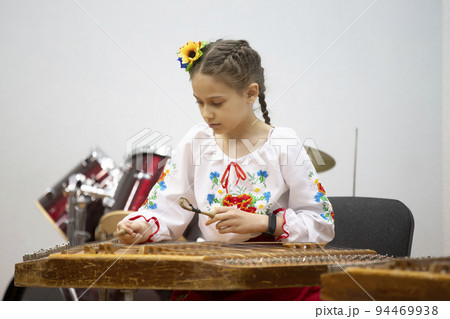 The girl plays the ethnic instrument dulcimer 94469938