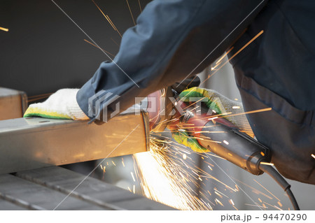 The welder cuts the pipe and fiery sparks fly.Worker cuts gas pipe with grinder, close up The welder cuts the pipe and fiery sparks fly.Worker cuts gas pipe with grinder, close up 94470290