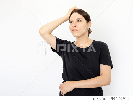 Portrait of young serious woman in black T-shirt looking up 94470919