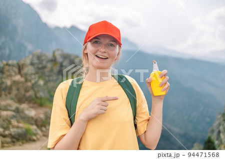 Woman applying insect repellent against mosquito and tick on her hand during hike in nature top mountain. Skin protection against insect bite Woman applying insect repellent against mosquito and tick on her hand during hike in nature top mountain. Skin protection against insect bite 94471568