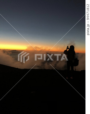 ハレアカラ火山からの夕焼けを撮影する人 94471812