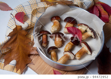 Vintage baking sheet with Imleria Badia or Boletus badius mushrooms commonly known as the bay bolete on wooden cutting board.. 94472952