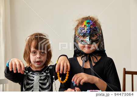 Kids in halloween costumes on white wall background 94473064