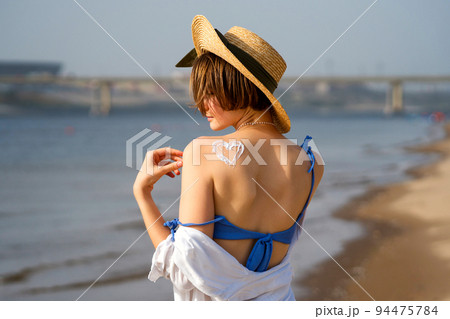 Woman with Sunscreen in form heart 94475784