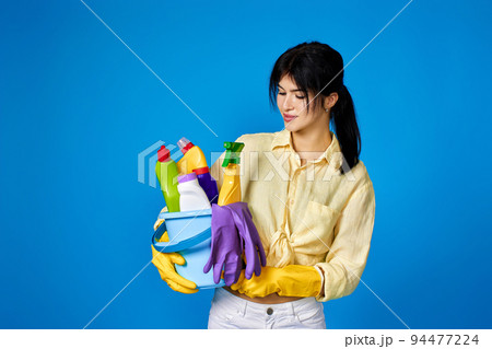 woman in gloves holding bucket with cleaning supplies woman in gloves holding bucket with cleaning supplies 94477224