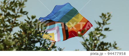 person flies a progress pride flag, web banner person flies a progress pride flag, web banner 94477958