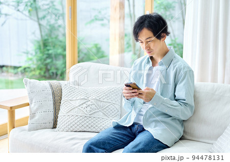 リビングでスマホを操作する男性 リビングでスマホを操作する男性 94478131