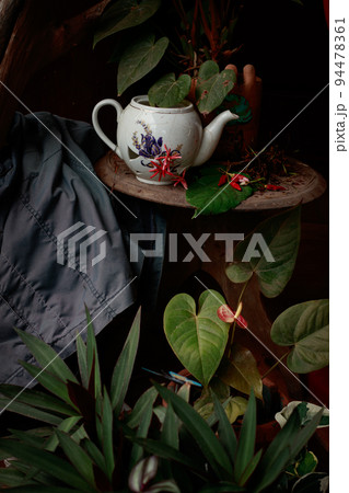 Broken vintage porcelain teapot on a coffee table shot in low light Broken vintage porcelain teapot on a coffee table shot in low light 94478361