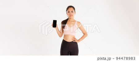 Sport, technology and active lifestyle concept. Dissatisfied and skeptical asian female athlete, sportswoman complaining on fitness application, showing smartphone screen disappointed Sport, technology and active lifestyle concept. Dissatisfied and skeptical asian female athlete, sportswoman complaining on fitness application, showing smartphone screen disappointed 94478983