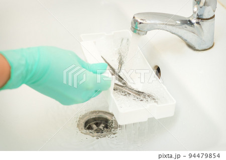 Hand in glove cleans the tweezers with water in-tray. Cleaning systems for tweezers Hand in glove cleans the tweezers with water in-tray. Cleaning systems for tweezers 94479854