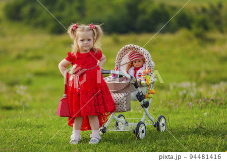 girl playing with a doll in a stroller girl playing with a doll in a stroller 94481416