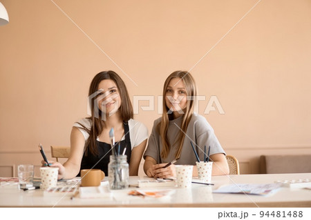 Front view of four beautiful caucasian female at art workshop. A young teacher teaches drawing Front view of four beautiful caucasian female at art workshop. A young teacher teaches drawing 94481488