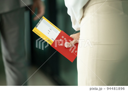 Japanese citizen handle Japan passport and flight ticket waiting to check in fly back to Japan or travel other country 94481896