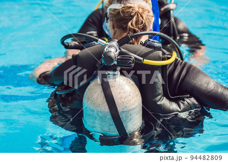 grey scuba diving air oxygen tank on the back of a scuba diver 94482809