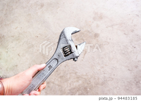 Adjustable spanner in a hand, industrial spanner isolated 94483185