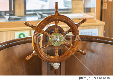 海賊遊覧船の中のニス塗りの木製の舵のクローズアップ。の写真素材