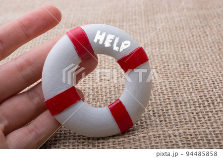 Hand holding a Lifesaver with  HELP wording beside 94485858