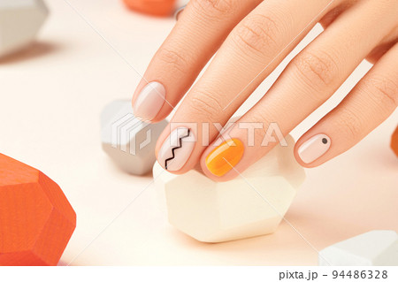 Manicured womans hand close up on beige background. Minimal spring autumn nail design 94486328