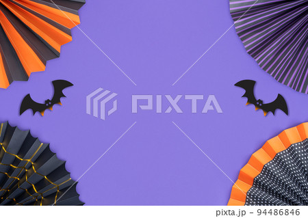 Halloween background. Frame made of bright paper fans and bats on purple background with copy space. Halloween background. Frame made of bright paper fans and bats on purple background with copy space. 94486846