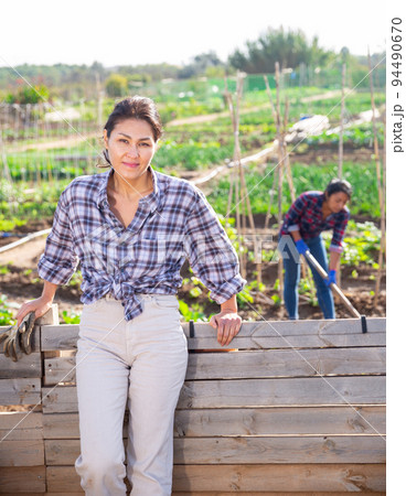 Female gardener posing with a shovel in garden 94490670