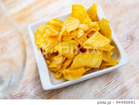 Plate of crispy deep-fried chips of thinly sliced potatoes Plate of crispy deep-fried chips of thinly sliced potatoes 94490691