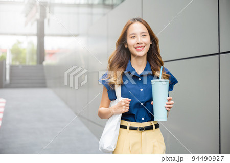 business woman confident smiling with cloth bag holding steel thermos tumbler mug water glass business woman confident smiling with cloth bag holding steel thermos tumbler mug water glass 94490927