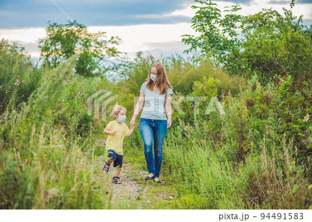 Mother and son in a medical mask because of an allergy to ragweed Mother and son in a medical mask because of an allergy to ragweed 94491583