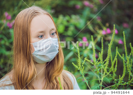 Young woman in a medical mask because of an allergy to ragweed Young woman in a medical mask because of an allergy to ragweed 94491644