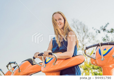 Beautiful, young woman having fun at an amusement park 94491790