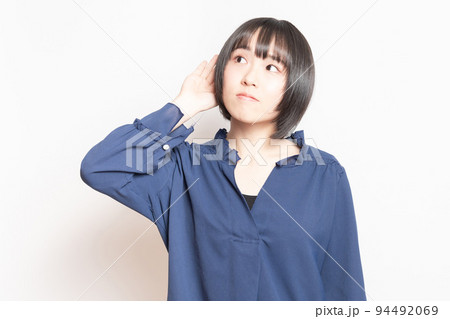 噂話を聞いている若い女性 94492069