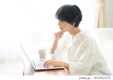 コピースペースが使いやすい綺麗な逆光の中仕事をする女性　考える 94492429