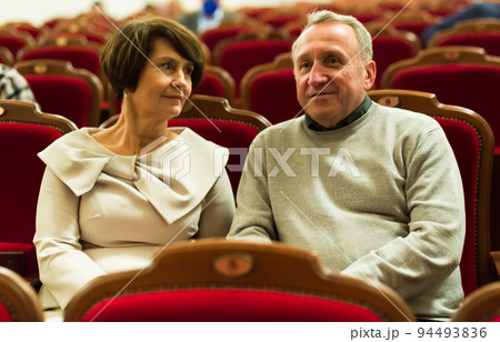 mature man and woman in theater watching a performance mature man and woman in theater watching a performance 94493836
