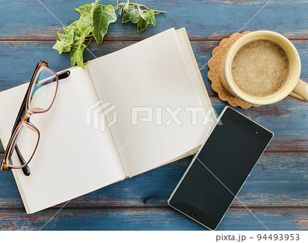 開いた本とコーヒーとスマホと眼鏡_俯瞰 開いた本とコーヒーとスマホと眼鏡_俯瞰 94493953
