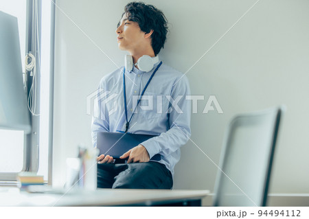 オフィスで働くカジュアル衣装の若い男性 94494112