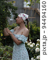 Woman examining branches in garden 94494160