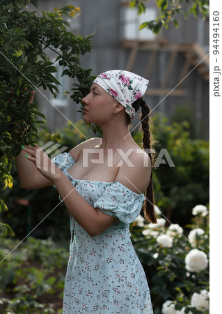 Woman examining branches in garden 94494160