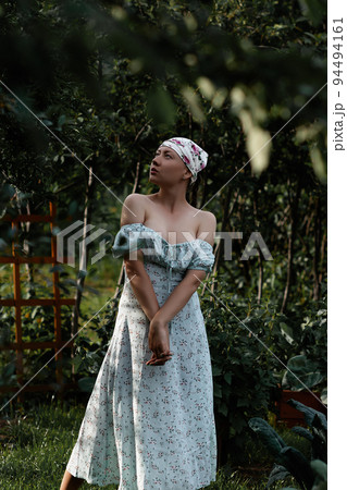 Woman examining branches in garden 94494161